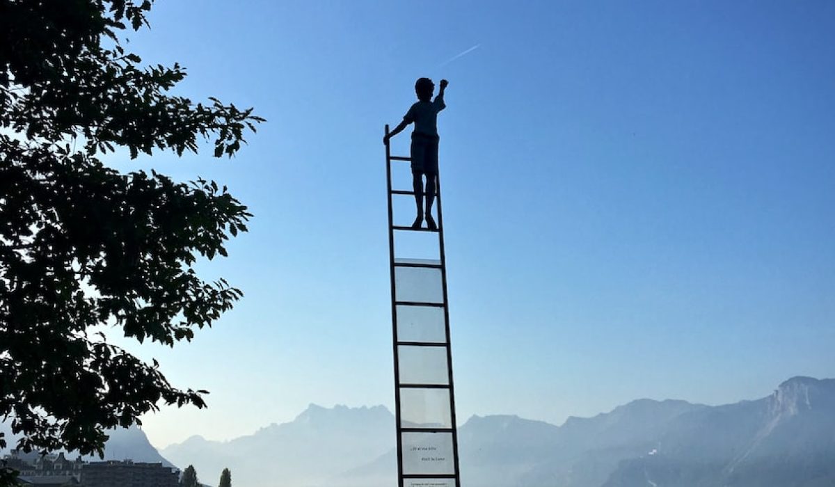 boy on ladder under blue sky